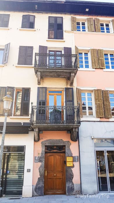 Façade mur rose et jaune et volet persienne marron