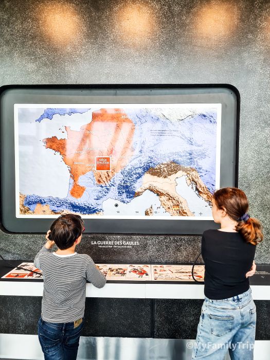 enfants qui écoutent een regardant une carte interactive - muséo parc Alesia
